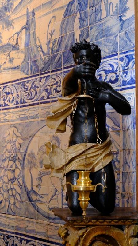 Carved figure against blue tiles